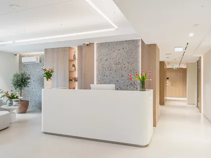 Soul Dental Studio administraatori laud: valge lett, kliiniku logo kivisel seinal, lilled